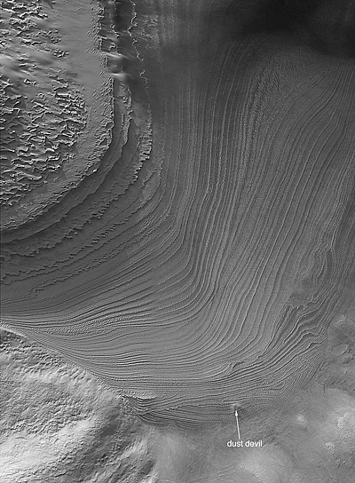 Cross-cutting layered rock exposure in Galle Crater, with label to indicate location of an active dust devil in the scene.