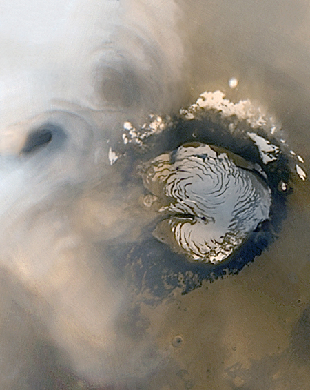 Color view of martian north polar cap and two nearby, white, circular cloud formations.