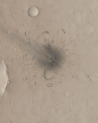 Colorized view of fresh impact site; small dark crater surrounded by dark rays and  secondary impacts; one set of rays is longer than the other an points toward the northwest.
