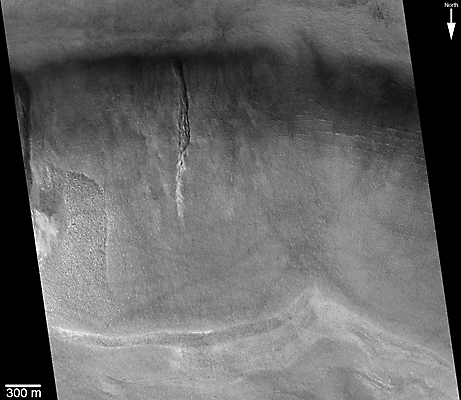Small portion of a crater wall, showing gully with light-toned apron deposit.